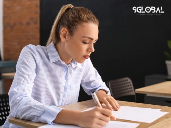 Góc chụp cận cảnh một nữ sinh đang viết bài, thể hiện sự nghiêm túc trong học tập và chuẩn bị tài chính. tổng chi phí du học Mỹ