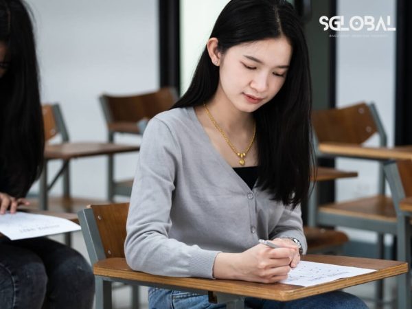 Nữ sinh đang tập trung làm bài thi học thuật, đại diện cho quá trình luyện thi học bổng Mỹ.