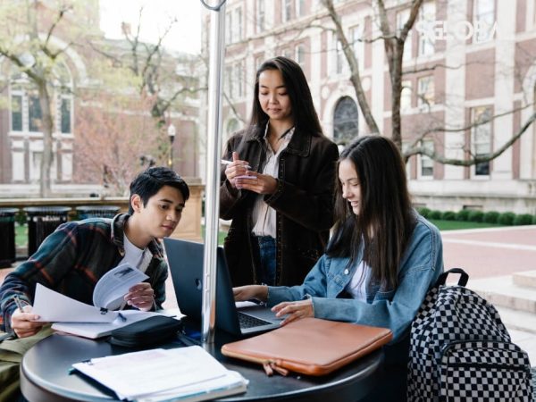 Ba sinh viên đang cùng nhau trao đổi và học tập tại không gian ngoài trời của trường đại học ở Canada.