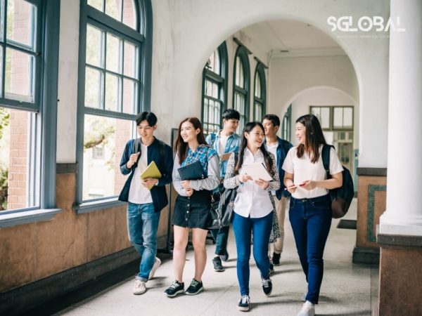 Nhóm du học sinh quốc tế bước đi trong hành lang cổ kính của một trường đại học tại Canada. Chú thích: