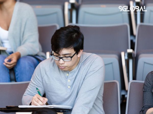 Sinh viên Việt Nam đang tập trung viết hồ sơ xin visa Mỹ trong khán phòng học thuật.