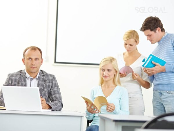 Giảng viên và sinh viên đang trao đổi học thuật, đại diện cho các khoản chi phụ như sách vở, tài liệu học.