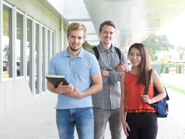 Nhóm sinh viên quốc tế tươi cười ngoài khuôn viên trường, phản ánh cơ hội học bổng và hỗ trợ tài chính.