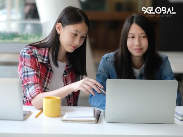 Hai nữ sinh đang cùng nhau hoàn thiện hồ sơ du học Đức trên máy tính.
